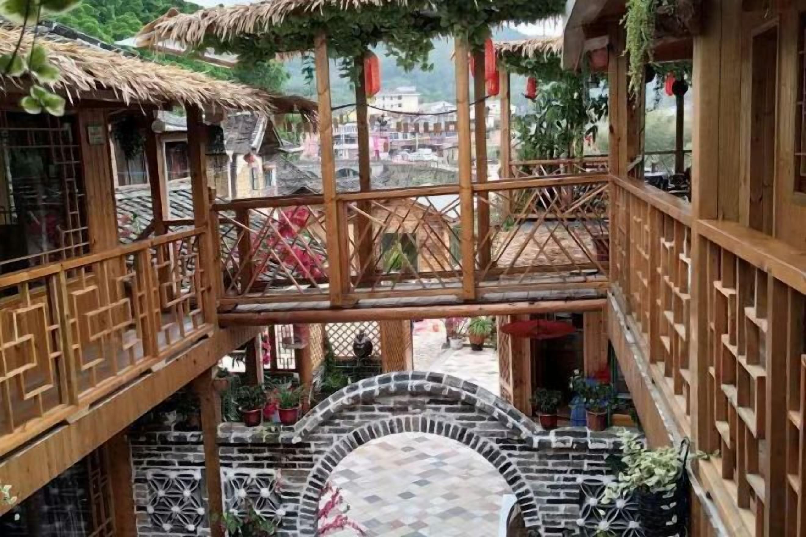 Una estructura de madera tradicional con techo de paja, una escalera central y una plataforma circular de piedra.