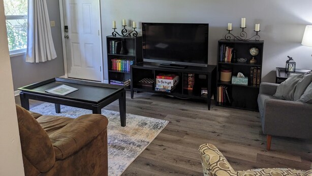 Een woonkamer met een flatscreen televisie, boekenkasten, een salontafel en een bank.