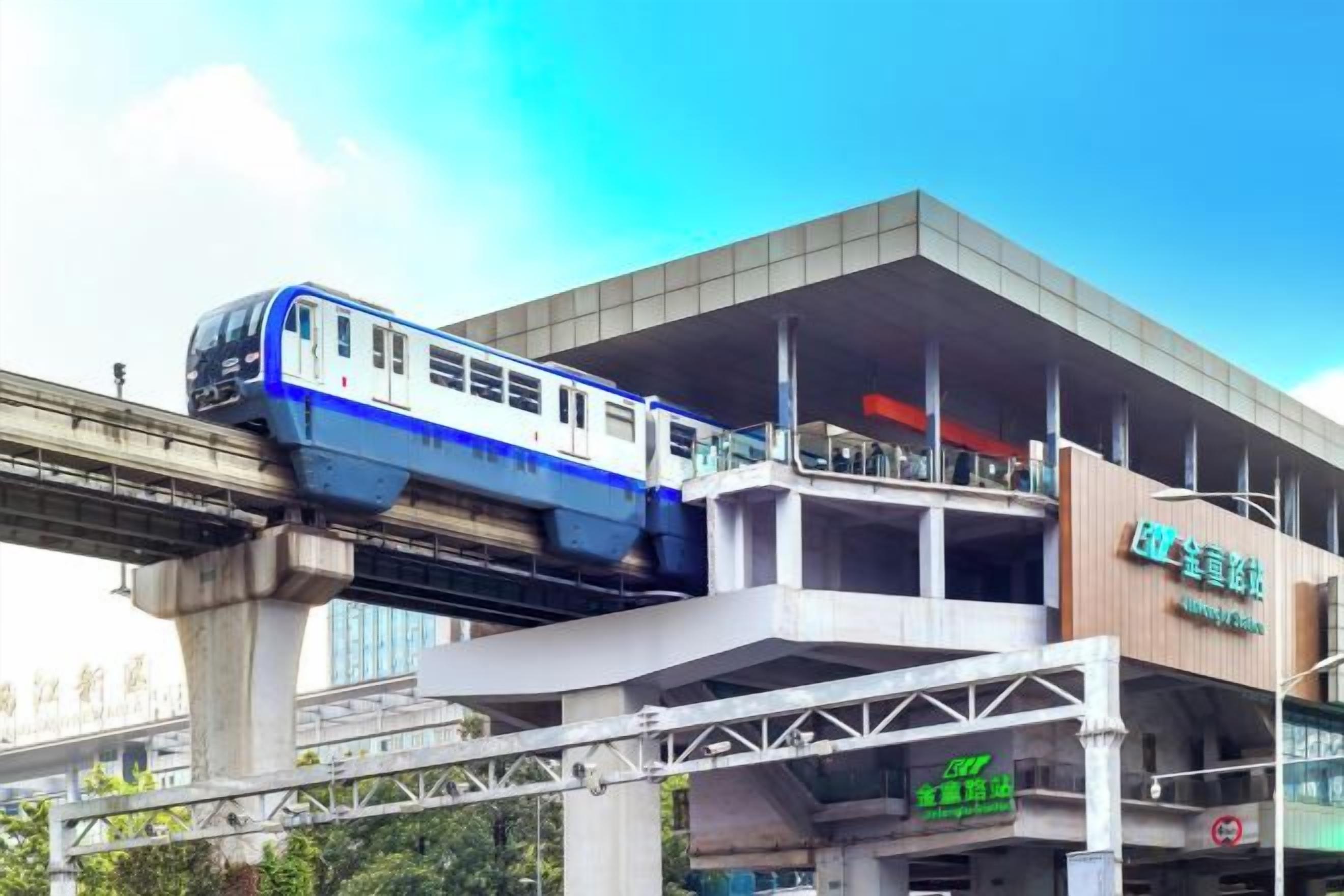 A train on an elevated track above a building with signage.