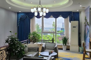 A hotel room with a balcony, a dining area, and a refrigerator. - Aegean Business Hotel (Chongqing Auto Expo Center Branch) (Chongqing)