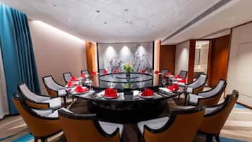A conference room with a round table, chairs, and a glass partition.