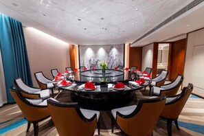 A conference room with a round table, chairs, and a glass partition. - Huayun Hotel (Yushan)
