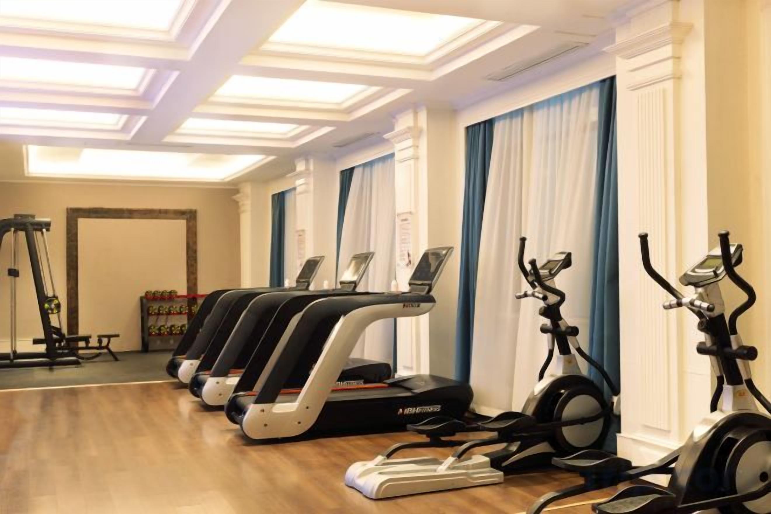 A gym with treadmills, stationary bikes, and a rowing machine.
