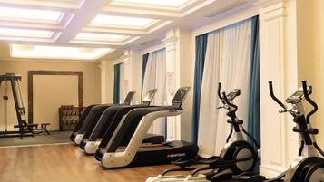 A gym with treadmills, stationary bikes, and a rowing machine.