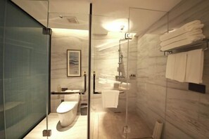 A modern bathroom with a glass shower enclosure, a toilet, a sink, and a towel rack. - Huayun Hotel (Yushan)