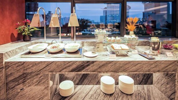 A buffet setup with various dishes and a marble countertop. - Huayun Hotel (Yushan)