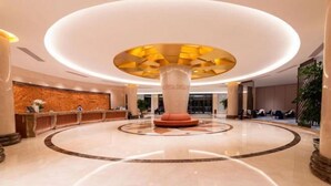 A spacious lobby with a central column, a reception desk, and a circular seating area. - Huayun Hotel (Yushan)