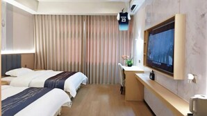 A hotel room with two beds, a desk, a TV, and a curtain. - Yueyan Business Hotel (Zhuhai)