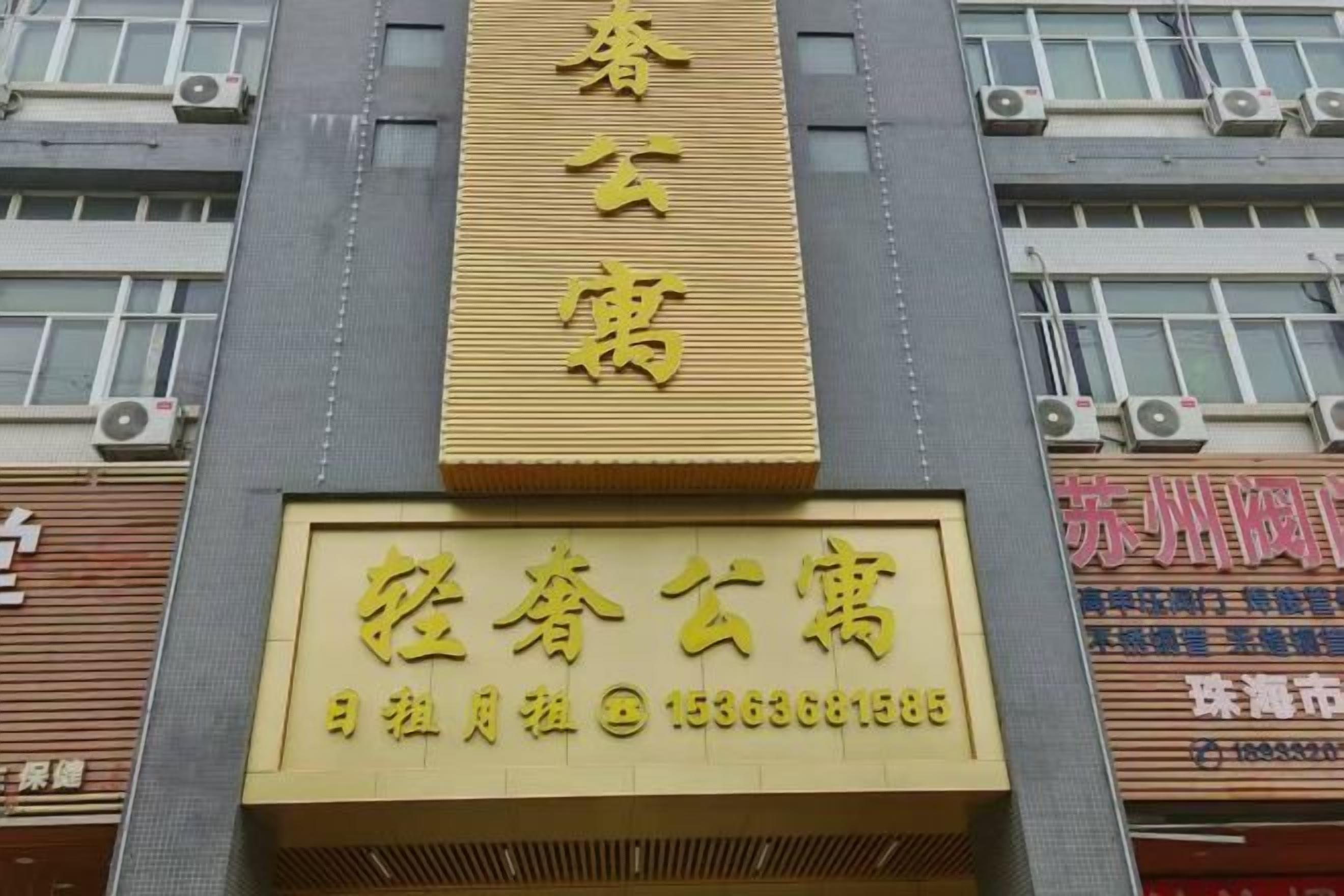 A building with a large sign that reads 'Spring Blossom' and a smaller sign below it with contact information.