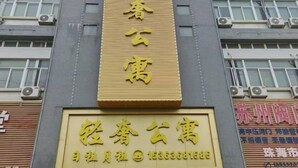 A building with a large sign that reads 'Spring Blossom' and a smaller sign below it with contact information. - Yueyan Business Hotel (Zhuhai)