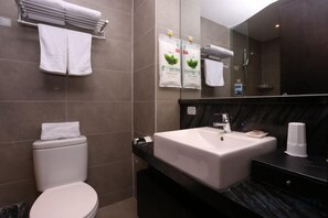 A modern bathroom with a toilet, sink, and towel rack.