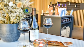 A table with a bottle of wine, two wine glasses, a jar of jam, and a loaf of bread. - Petite Bastide | Domaine Tour Campanets (Le Puy-Sainte-Réparade)