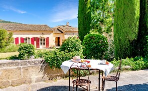 Guests can dine al fresco in a charming garden setting, surrounded by lush greenery and a beautifully maintained outdoor space.