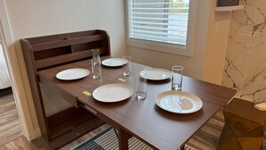 A dining table with four plates, two glasses, and a wooden chair. - Mountain Bluebird Condo Getaway at Schweitzer Ski Resort (Sandpoint)