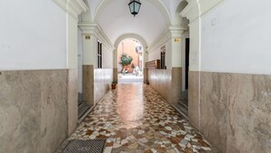 Ein Korridor mit Fliesenboden, weißen Wänden und einer gewölbten Decke.