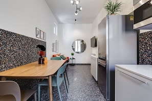 Une cuisine moderne avec un coin repas, des plans de travail en granit et un miroir rond.