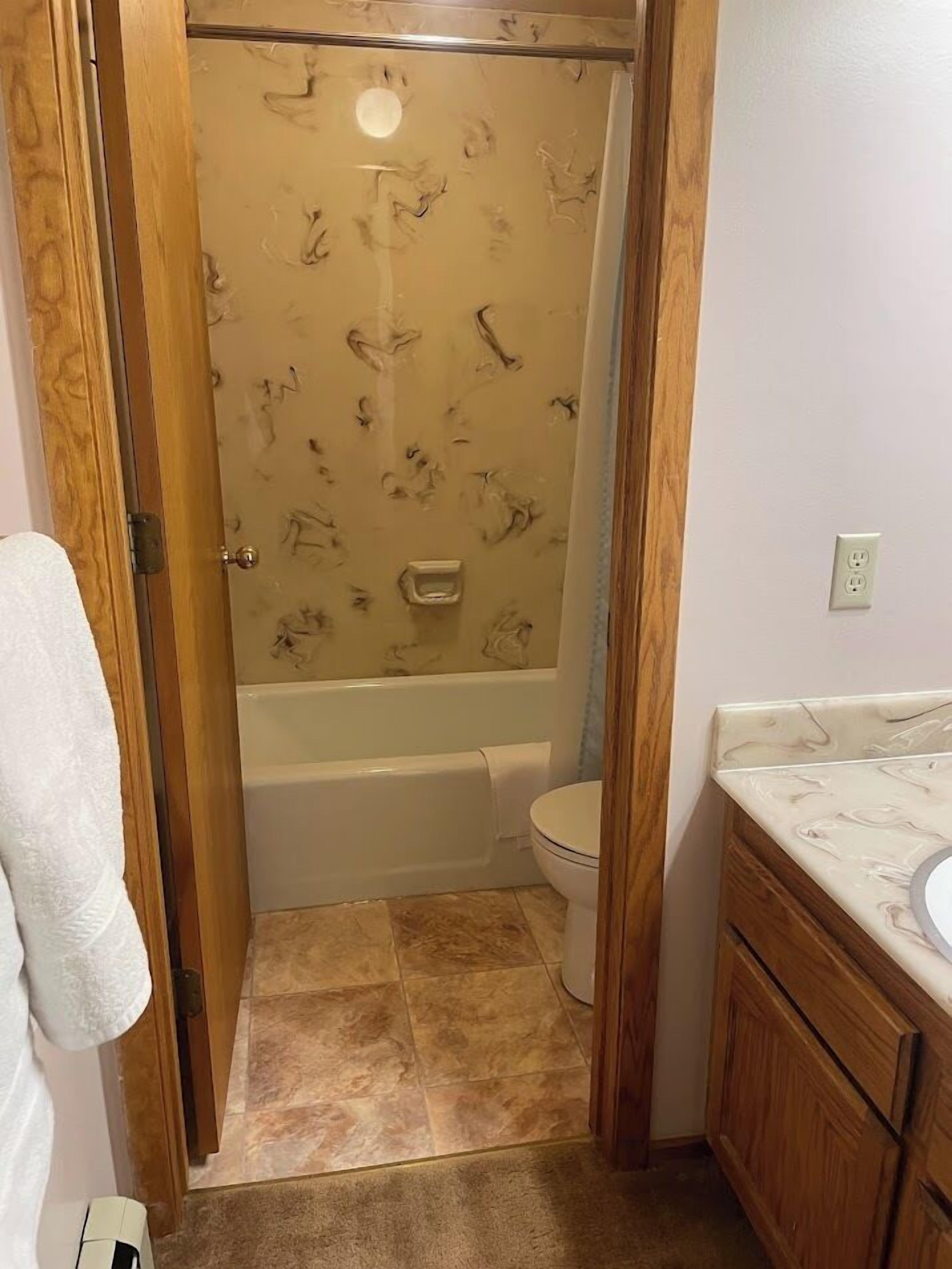 Une salle de bain avec douche, toilettes et lavabo.