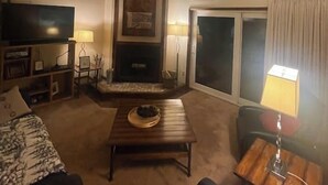 A cozy living room with a fireplace, a television, and a comfortable seating area. - Ski in/out condo with three queens (Eden)