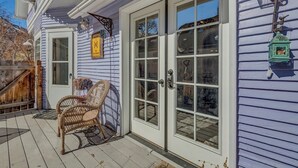 A house with a porch, a wicker chair, and a green lantern. - Downtown Rustic Luxury Garden Suite (Glenwood Springs)
