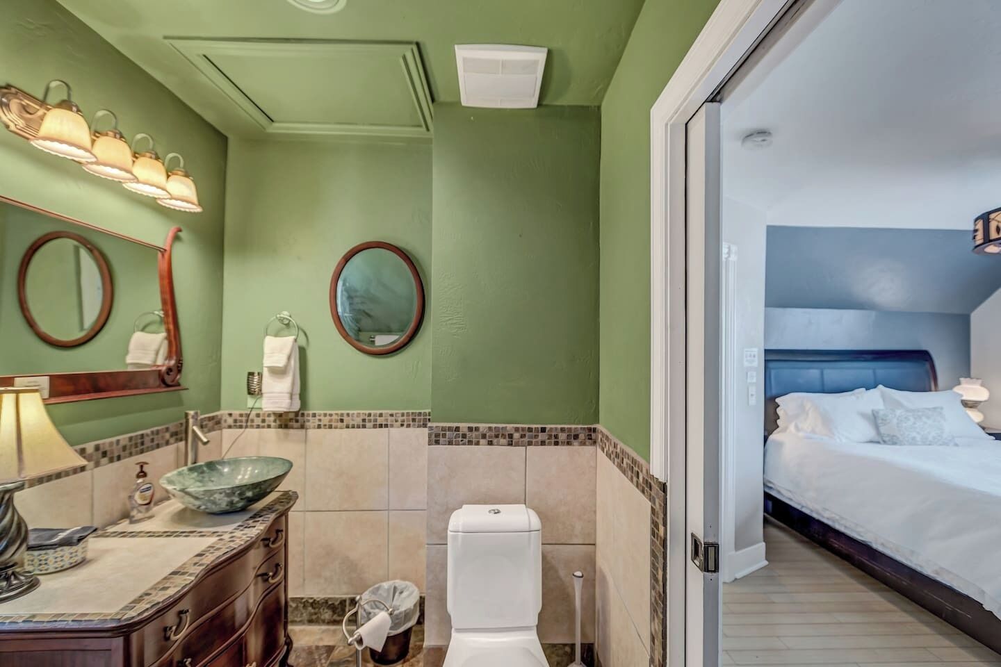 Un baño de hotel con lavamanos, espejo y retrete.