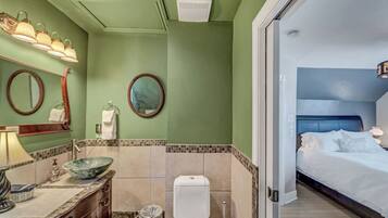 Un baño de hotel con lavamanos, espejo y retrete.