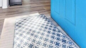 A hallway with a blue door, a refrigerator, and a patterned rug. - A cozy cottage in Sequoia area! (Three Rivers)