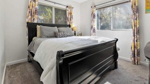 A bedroom with a bed, two windows, and curtains. - A cozy cottage in Sequoia area! (Three Rivers)