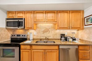 A kitchen with wooden cabinets, stainless steel appliances, a Bosch dishwasher, and a Bosch coffee maker.
