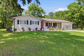 A single-story house with a front porch, a red door, and a small front yard. - Pet-Friendly 3BR | Fenced Yard (Smithfield)