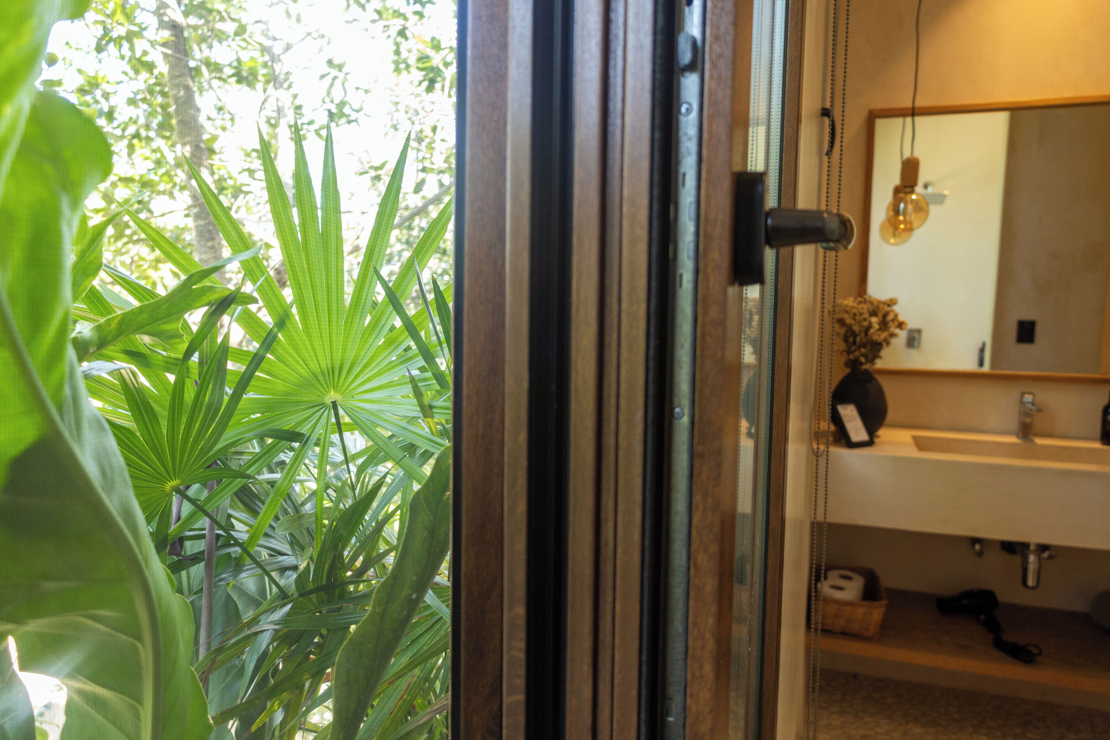 A bathroom with a sink, mirror, and a hanging light fixture.