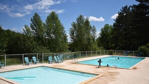 Two rectangular swimming pools with blue chairs and a fence. - Chalet avec piscine au Domaine du Lac de Goulens (LAYRAC)