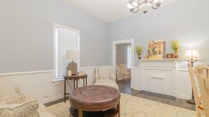 Una sala de estar con sofá, reposapiés y chimenea.