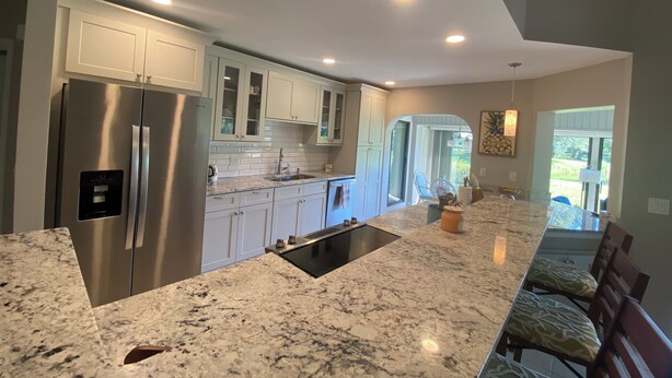 A modern kitchen with a large island, stainless steel appliances, and white cabinetry. - Tranquil Lake view 2 Bedroom 2 bath Villa in Myrtle Trace (Venice)