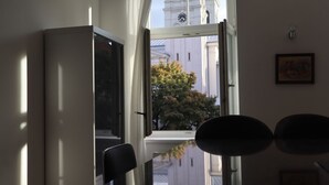 Huone, jossa on suuri ikkuna, tuoli ja ovi.