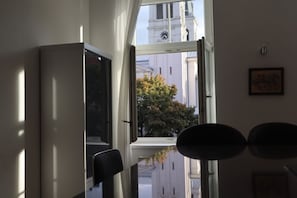 Ein Zimmer mit großem Fenster, einem Sessel und einer Tür.
