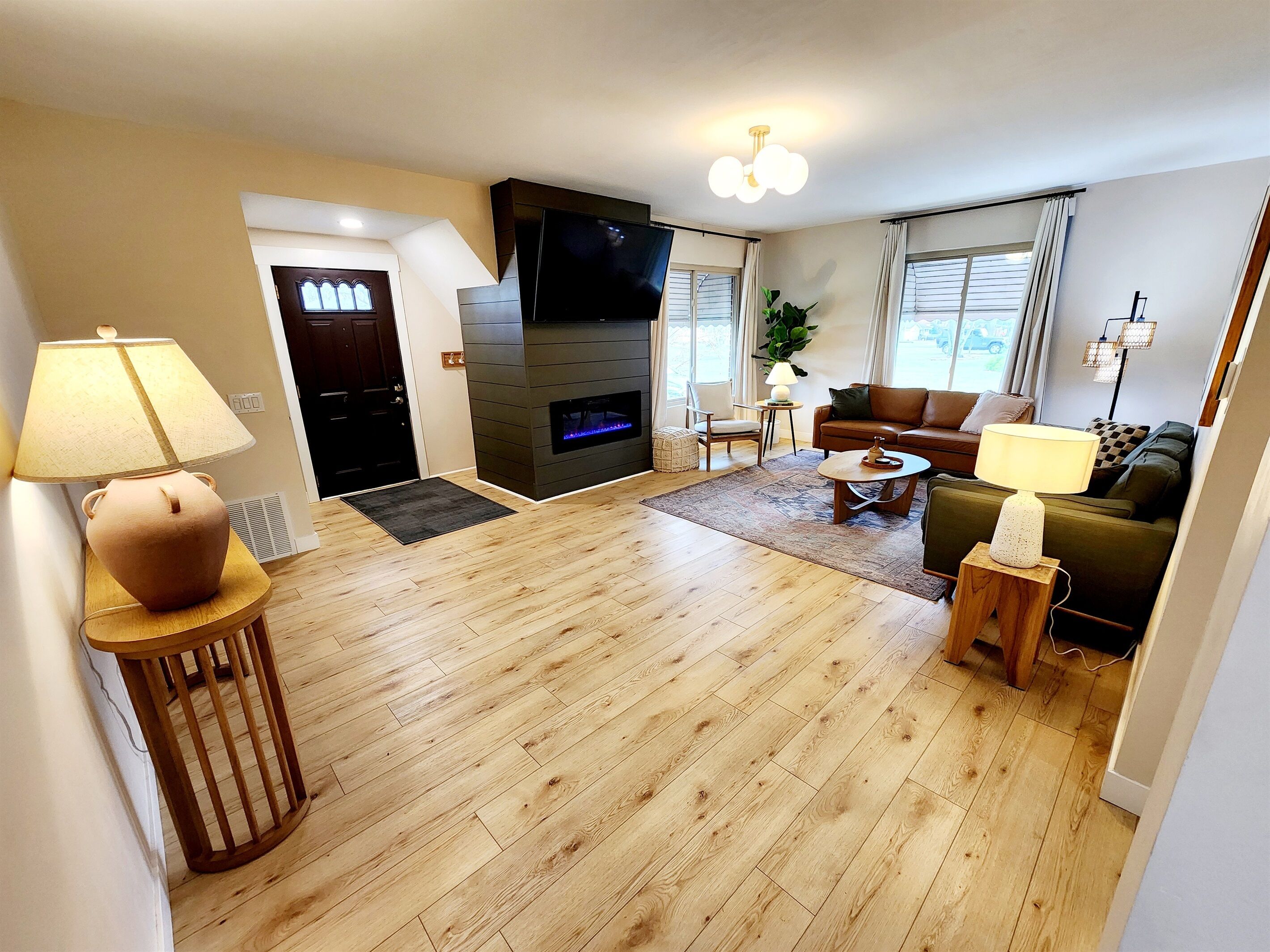 A modern living room with a fireplace, a sofa, a coffee table, and a TV.