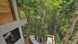 Ein moderner Poolbereich im Freien mit zwei Liegestühlen und einer Holzterrasse.