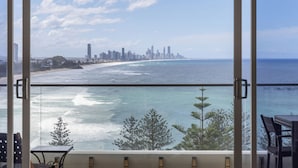 A balcony with a view of a coastal cityscape, including a beach and a city skyline. - Burleigh Headland 2 Bedroom Stay, just a stones throw from the beach! (Burleigh Heads)