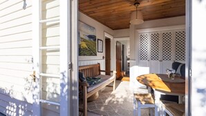 Un intérieur chaleureux avec un banc en bois, une table avec des chaises et une vue sur l’extérieur.
