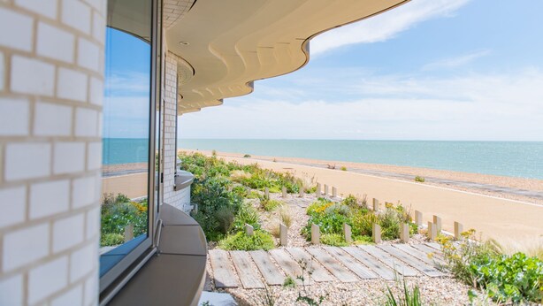 A view from a balcony overlooking a beach with a clear sky.