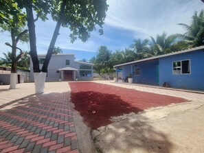 Un bâtiment moderne doté d’une cour dallée et d’un revêtement de sol rouge.