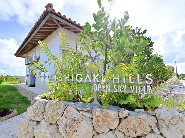 A building with a stone wall in front, labeled "HIGAKI HILLS OPEN SKY VILLAGE."