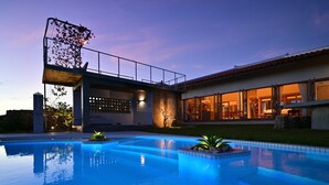 A modern house with a swimming pool, featuring a large glass door and a stone wall. - Ishigaki hills (Ishigaki)