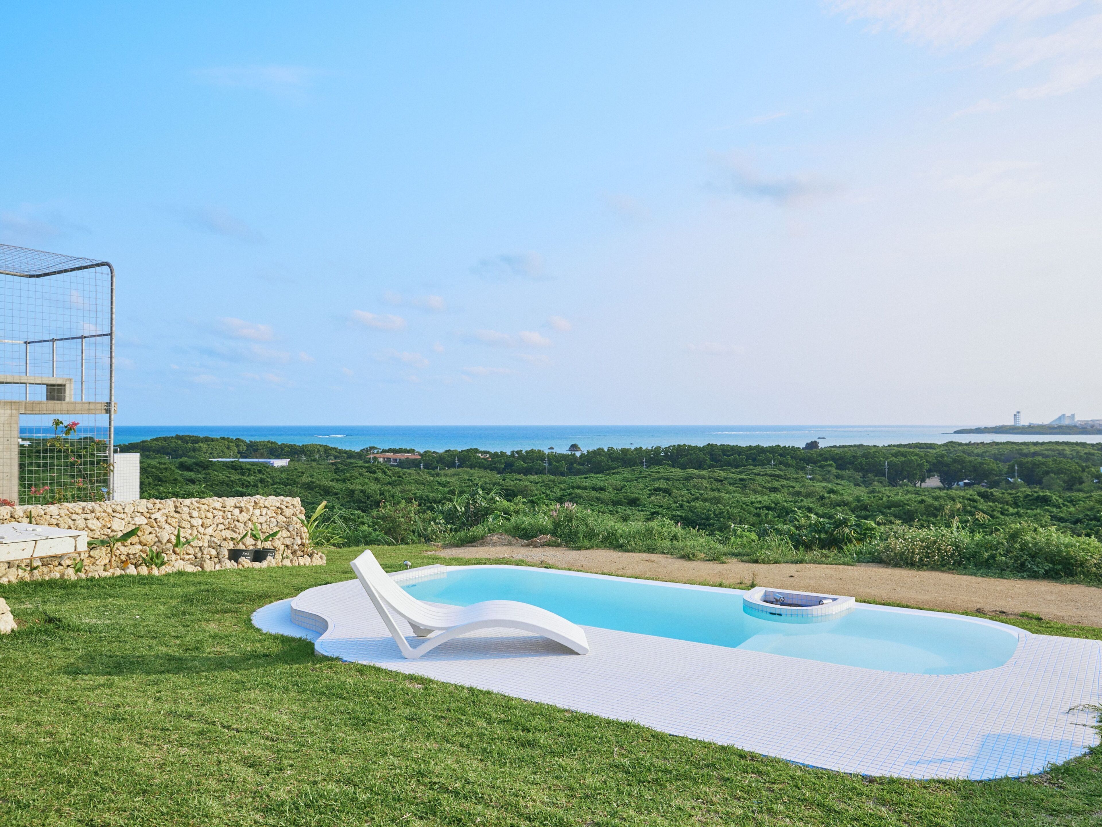 Une piscine avec vue sur la mer et la verdure.