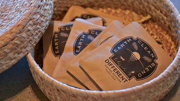 Una cesta tejida llena de bolsas de café con la etiqueta 'Earth Clean Planet'.