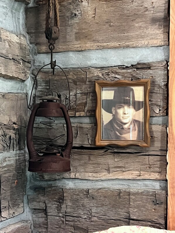 Pared rústica con una fotografía enmarcada y una tetera colgante.