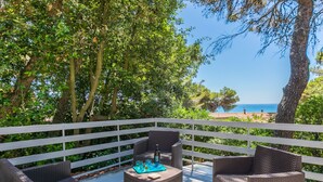 Un espace extérieur aménagé avec des meubles en osier et offrant une vue sur la mer.
