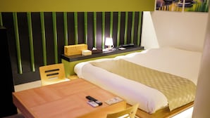 Ein Hotelzimmer mit Bett, Nachttisch, Stuhl und einem Kopfteil mit vertikalen Linien.