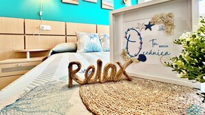 Ein Schlafzimmer mit Bett, Nachttisch, Wandlampe und einem gerahmten Kunstwerk mit Text.