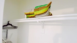A white closet with a striped towel hanging on a rod and a striped bag on a shelf. - Central Miami Studio w/ Parking - Coconut Grove (Miami)